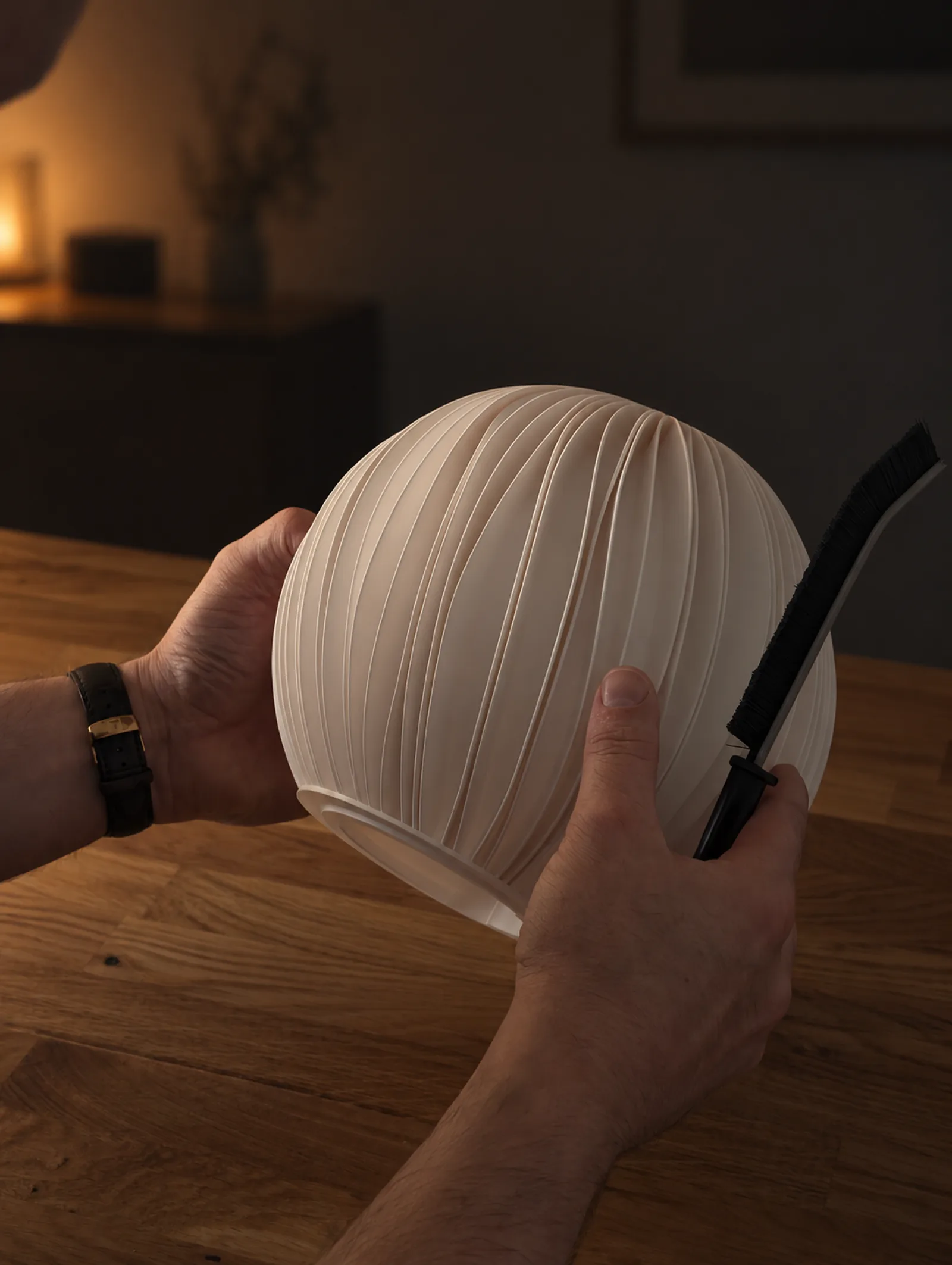 Hands brushing down a finished Rima lamp during inspection